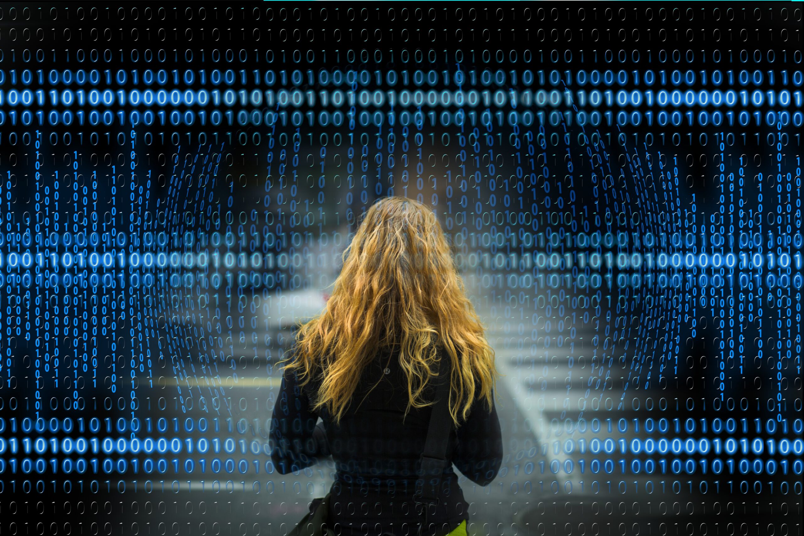 Female digital analyst viewing a wall of binary code representing TLD USA data driven SEO, AI systems, web development, and cybersecurity infrastructure in Arizona