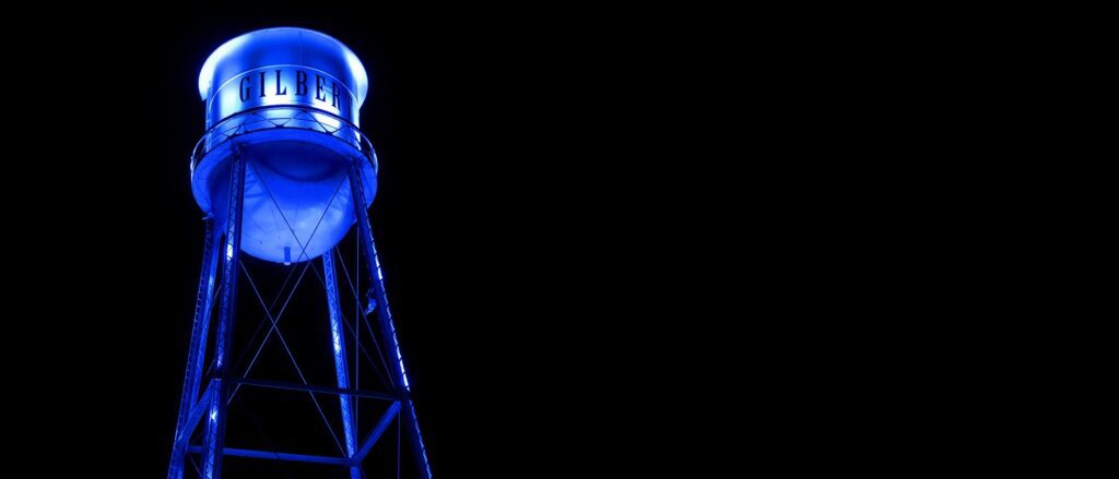 Illuminated blue Gilbert Arizona water tower at night - TLD USA Gilbert digital agency hero banner